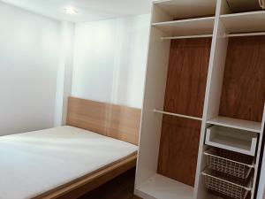 een kleine kamer met een bed en een kast bij Full Smile residence in Ban Zong Katiam