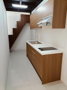 een keuken met een wastafel en een trap bij Full Smile residence in Ban Zong Katiam