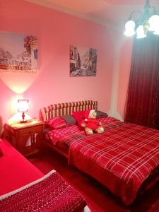 - un ours en peluche assis sur un lit dans une chambre dans l'établissement Guest House Cinderella, à Herceg-Novi