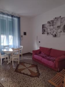 a living room with a purple couch and a table at Villa il sole in Genova