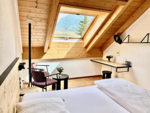 a bedroom with a bed and a window at Hotel Central La Fainera Superior in Valchava