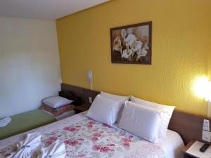 una habitación de hotel con una cama y una foto en la pared en Pousada da Baronesa, en Nova Petrópolis