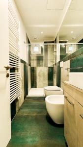 uma casa de banho com 2 lavatórios, um WC e um chuveiro em Hotel Vienna em Pesaro