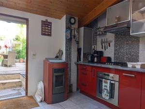 a kitchen with red cabinets and a stove top oven at The Bean Barn in Arçais