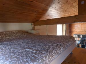 Bett in einem Zimmer mit Holzdecke in der Unterkunft The Bean Barn in Arçais