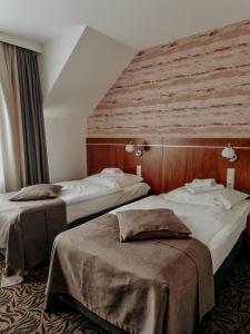 a hotel room with two beds and a wall at Hotel Azyl in Kąty Wrocławskie