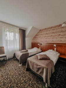 a hotel room with two beds and a chair at Hotel Azyl in Kąty Wrocławskie