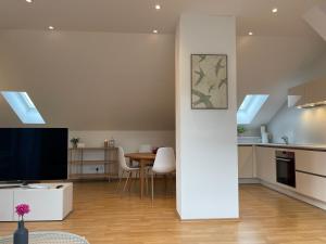 a kitchen and living room with a television and a table at Ferienwohnung Huimelig im Allgäu in Röthenbach