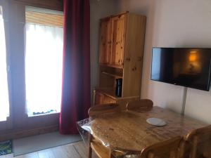 sala de estar con mesa y TV de pantalla plana en L'enclaves, en Les Contamines-Montjoie