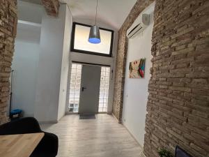 un pasillo con una pared de ladrillo y una luz azul en Estudio para parejas en Barcelona