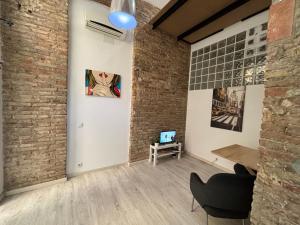 a room with a brick wall and a table and a painting at Estudio para parejas in Barcelona