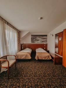 une chambre d'hôtel avec deux lits et une chaise dans l'établissement Hotel Azyl, à Kąty Wrocławskie