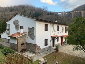 an old house with a fireplace and a bridge in the background at Podere Campofossato in Pistoia