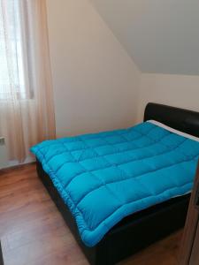 un grande letto blu in una stanza con finestra di Pelister Riverside Villa a Bitola