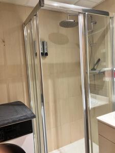 y baño con ducha y puerta de cristal. en APARTAMENTO PINAPLAYA, en Grao de Castellón