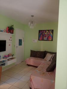 ein Wohnzimmer mit einem Bett und einem TV in der Unterkunft Comodidade sempre in São José dos Campos