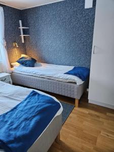 dwa łóżka w pokoju z krzyżem na ścianie w obiekcie Toppstugan w mieście Åkerö