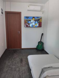a room with a bed and a door and a guitar at Casa contenedor super cómoda in La Floresta