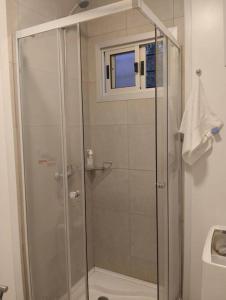 a shower with a glass door in a bathroom at Casa contenedor super cómoda in La Floresta
