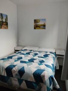 ein Schlafzimmer mit einem Bett und zwei Bildern an der Wand in der Unterkunft Casa contenedor super cómoda in La Floresta
