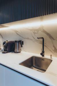 a kitchen counter with a sink and a coffee pot at Apartments Vitenberg in Cēsis