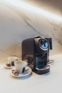 a coffee maker and two cups on a table at Apartments Vitenberg in Cēsis