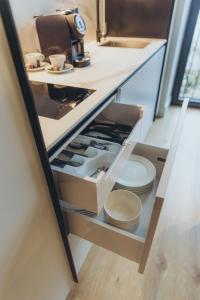 an open drawer in a kitchen with plates and cups at Apartments Vitenberg in Cēsis