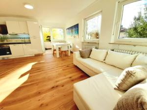 a living room with a white couch and a table at City Apartment Starnberg in Starnberg