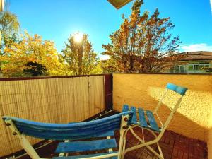 a blue rocking chair sitting next to a fence at City Apartment Starnberg in Starnberg