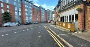 an empty city street with cars parked on the street at Business & Leisure City Centre 2 Bed En-suite Apartment with free parking and Netflix in Coventry