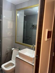 a bathroom with a sink and a toilet and a mirror at Lady Di Suite in Makati in Manila