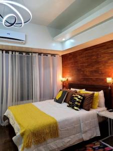 a bedroom with a bed with a yellow blanket at Lady Di Suite in Makati in Manila