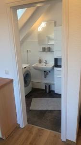 uma casa de banho com um lavatório e uma máquina de lavar roupa em Großzügige Wohnung Bochum-Gerthe em Bochum