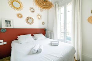 a bedroom with a white bed with white shoes on it at La Maioneta Vieux-Nice in Nice