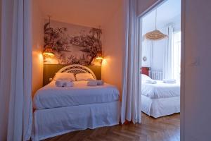 a bedroom with two beds and a painting on the wall at La Maioneta Vieux-Nice in Nice