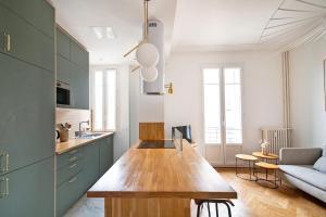 a kitchen with green cabinets and a wooden counter top at La Maioneta Vieux-Nice in Nice