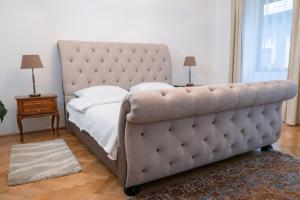 a bed with a tufted headboard in a bedroom at Casa Puscariu in Braşov