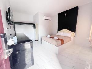 a hotel room with a bed and a television at BM Beach Resort Satun บีเอ็มบีชรีสอร์ท in Ban Pak Ba Ra