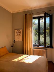 una camera da letto con un letto e una finestra di Casa d'epoca con giardino 5 min da Locarno a Minusio