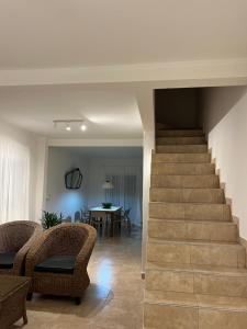 a staircase in a living room with chairs and a table at Duplex del Río in Concordia