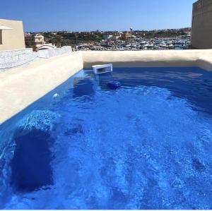 uma piscina com água azul no topo de um edifício em Hotel Medusa em Lampedusa