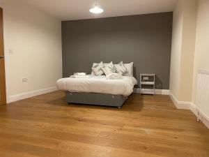 a bedroom with a bed in a room with wood floors at Two Bedroom Duplex Apartment The Priory in St Ives