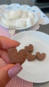 una persona che tiene in mano un piatto con biscotti a forma di cuore di FLAT EM ALPHAVILLE HOTEL CONFORT MELHOR LOCALIZAÇÃo a Barueri