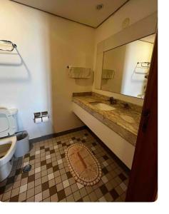 y baño con lavabo, espejo y aseo. en FLAT EM ALPHAVILLE HOTEL CONFORT MELHOR LOCALIZAÇÃo, en Barueri