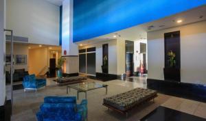 um átrio com cadeiras azuis e uma mesa num edifício em FLAT EM ALPHAVILLE HOTEL CONFORT MELHOR LOCALIZAÇÃo em Barueri