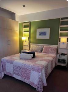 a bedroom with a large bed and green walls at FLAT EM ALPHAVILLE HOTEL CONFORT MELHOR LOCALIZAÇÃo in Barueri