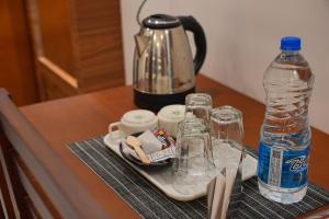 a table with a tea kettle and a bottle of water at Silverstone Inn in Nedumbassery