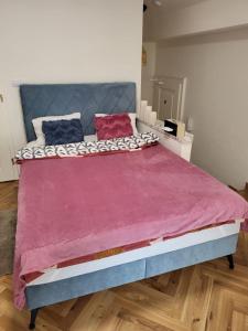 a bedroom with a large bed with a purple blanket at Apartment Prague Center in Prague