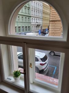 an arched window with a view of a parking lot at Apartment Prague Center in Prague