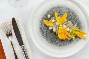 un piatto bianco con cibo su un tavolo di Hotel Cesare a San Marino